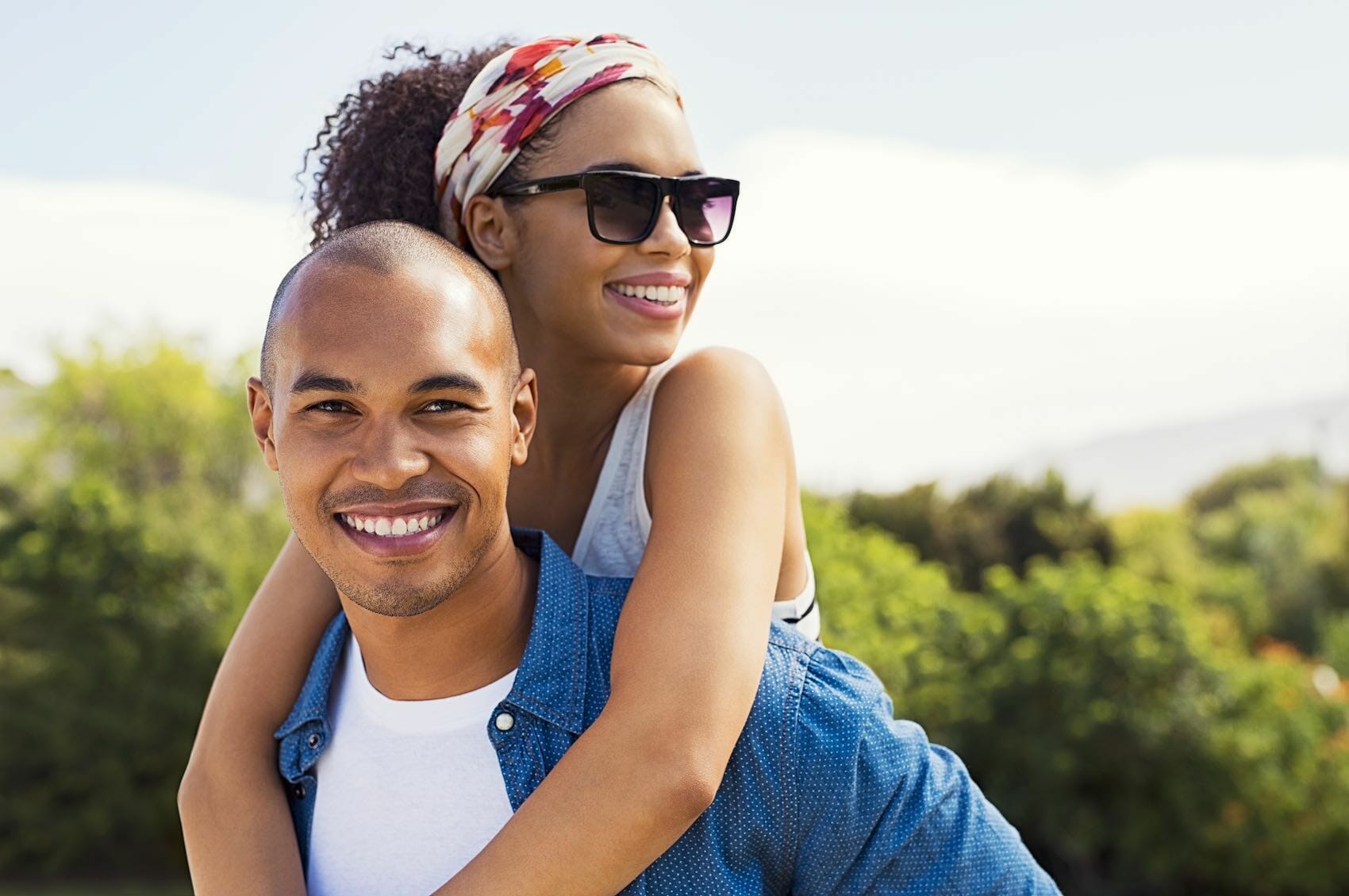 Portrait of a young couple outdoors with green foothills in the background