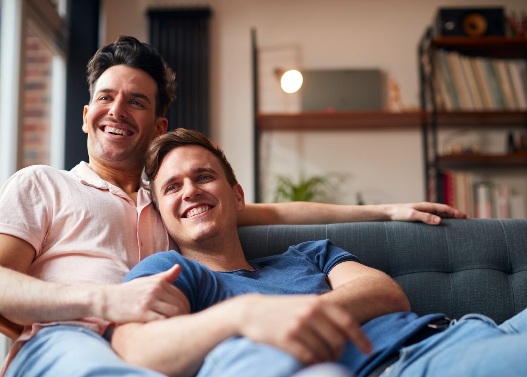 Couple Lying On Sofa At Home Watching TV